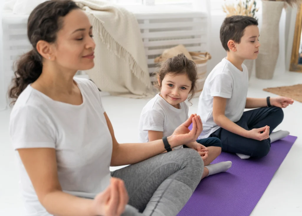 A mother and her two children meditating together at home