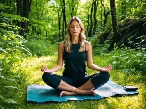 Woman meditating in a peaceful forest surrounded by trees and nature