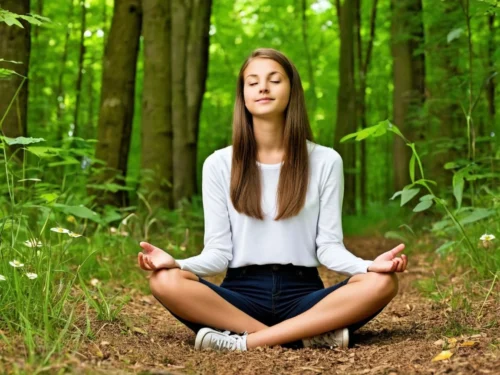 A teenage girl meditating peacefully in a lush forest, eyes closed, hands resting on her knees, surrounded by towering trees and soft natural light
