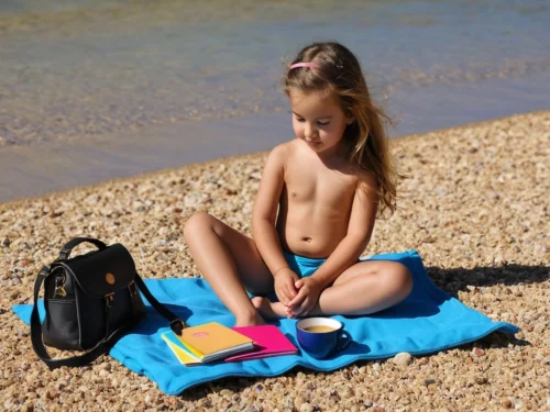 Young girl sitting calmly on beach sand in peaceful meditation pose