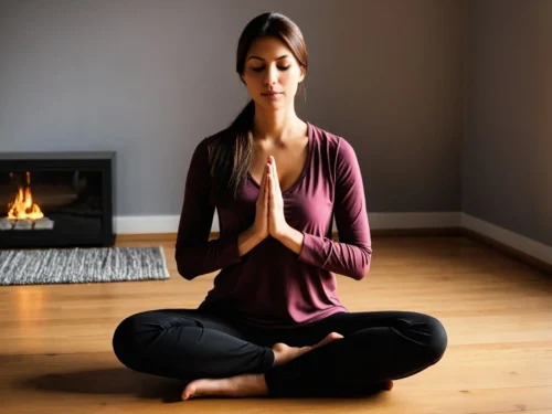 Woman sitting on the floor in meditation pose in her living room with peaceful expression