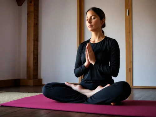 Woman practicing mindfulness meditation sitting cross-legged on living room floor in comfortable home setting
