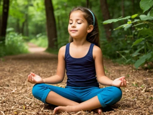 Little girl meditating on the forest floor among trees, finding calm for the back-to-school season